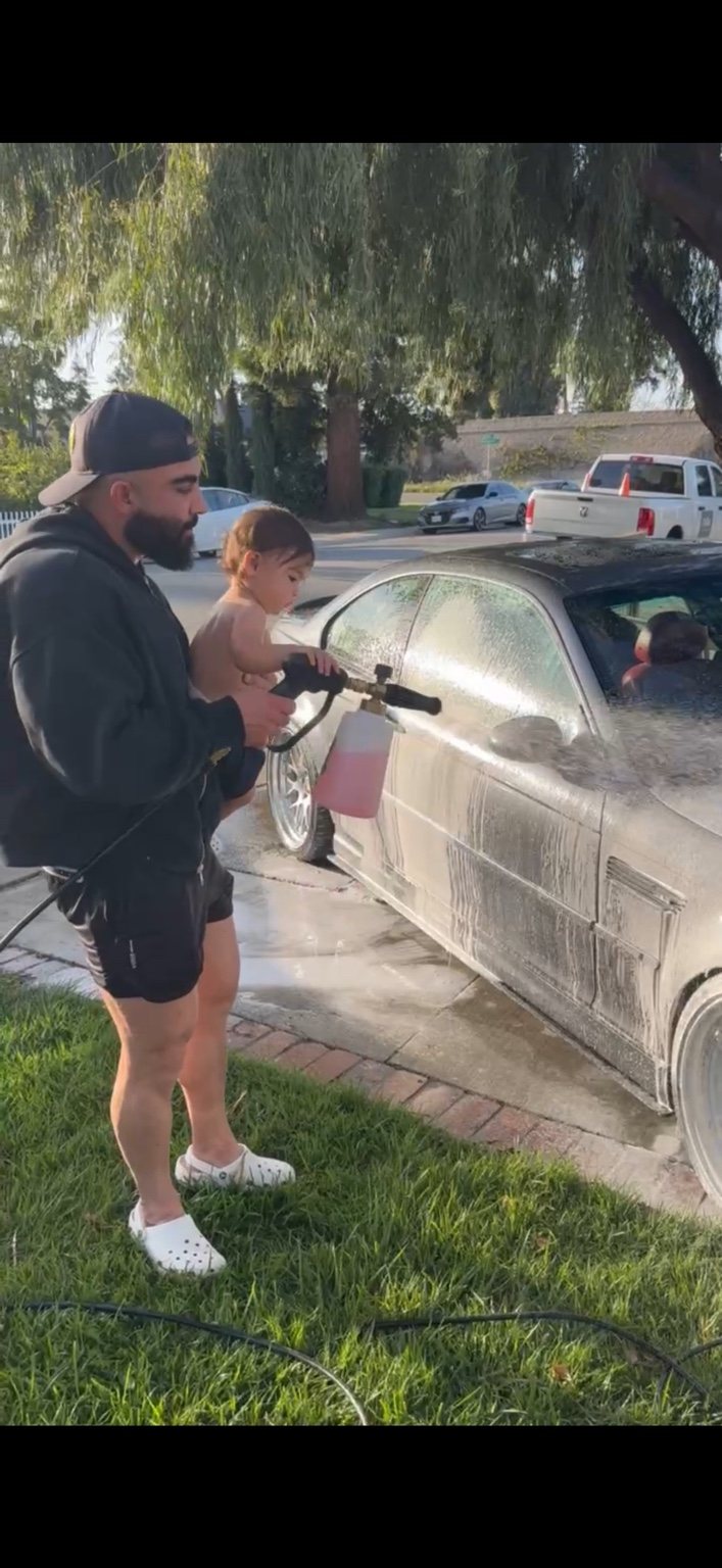 Daniel washing a car with his child